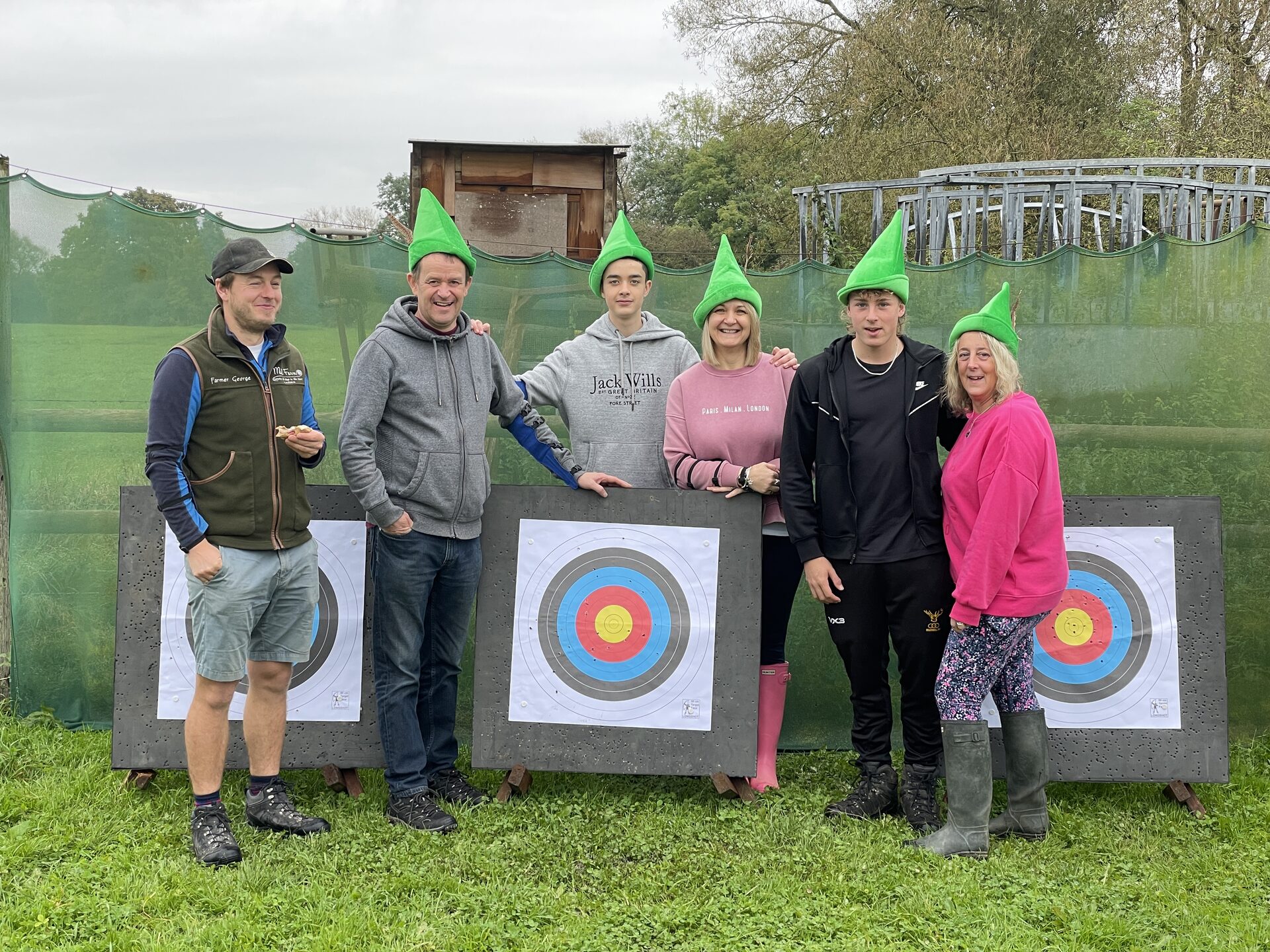 A group posing with their archery targets at Mill Farm Glamping