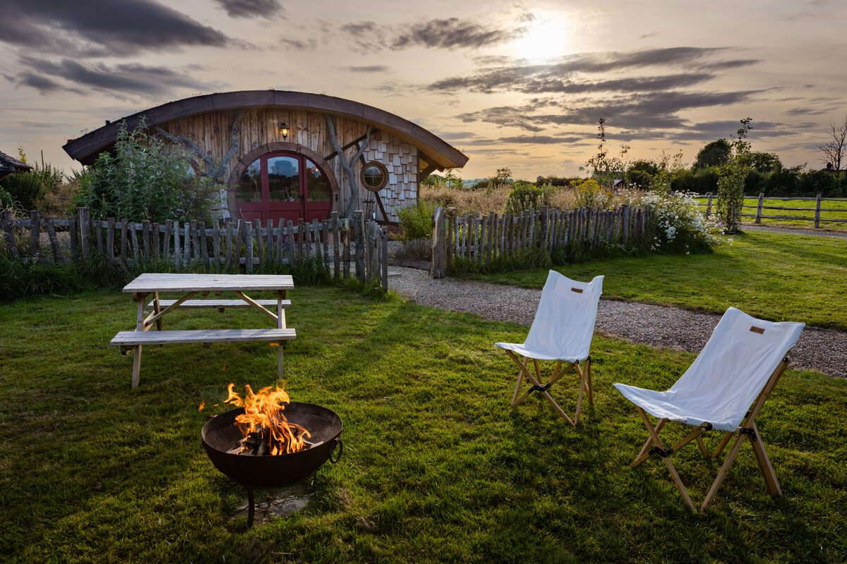 Evening fire pit with the Shire House glowing behind